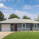 a front view of a house with a garden and yard