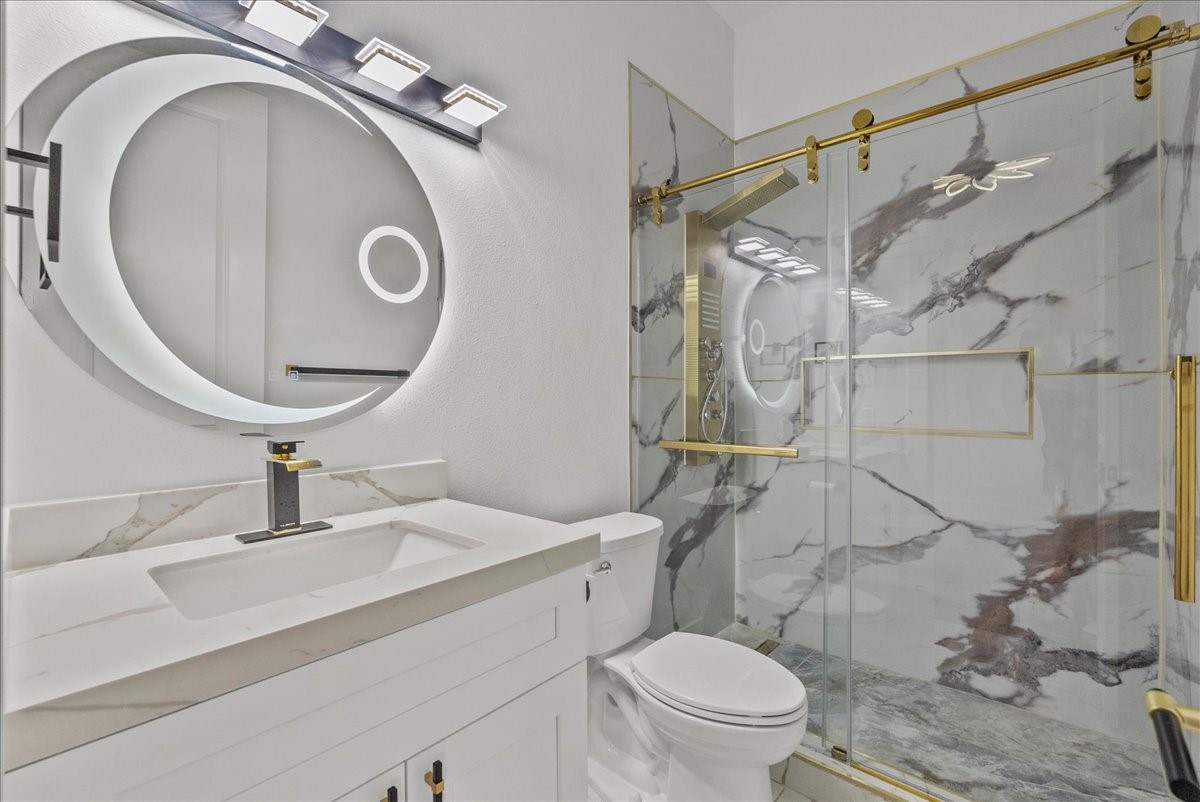 3237 Harkey Road Pearland, TX 77584 - Photo 22 of 46 Stylish en-suite secondary bath in second downstairs bedroom with marble-look finishes and gold accents