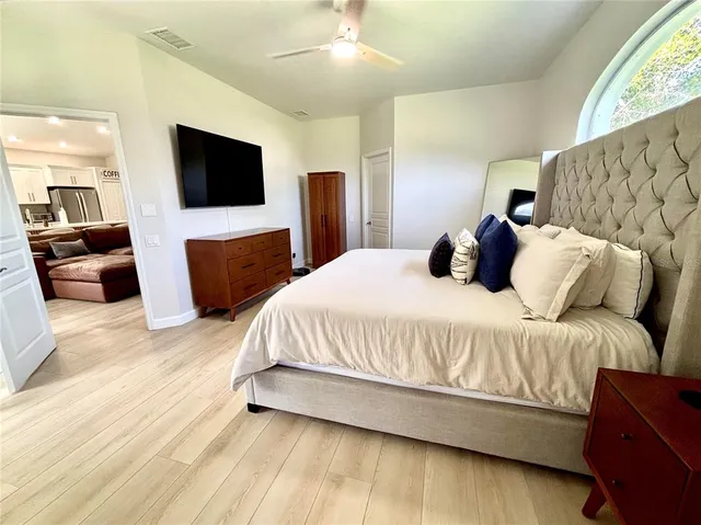 a spacious bedroom with a bed and a flat screen television