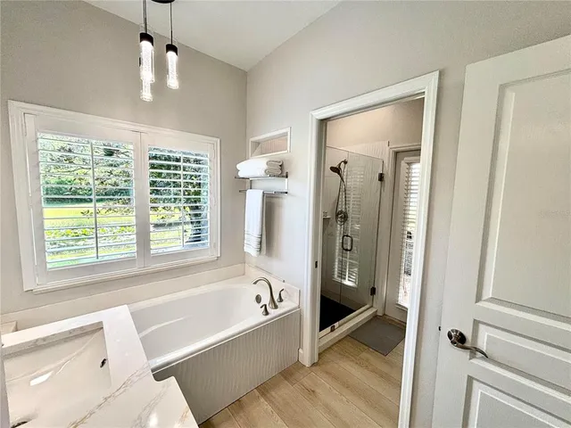 a bathroom with a tub shower and sink