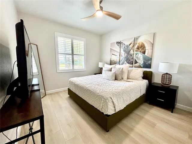 a bedroom with a bed and a flat tv screen on dresser