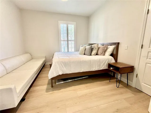 a bedroom with a bed lamp and a potted plant