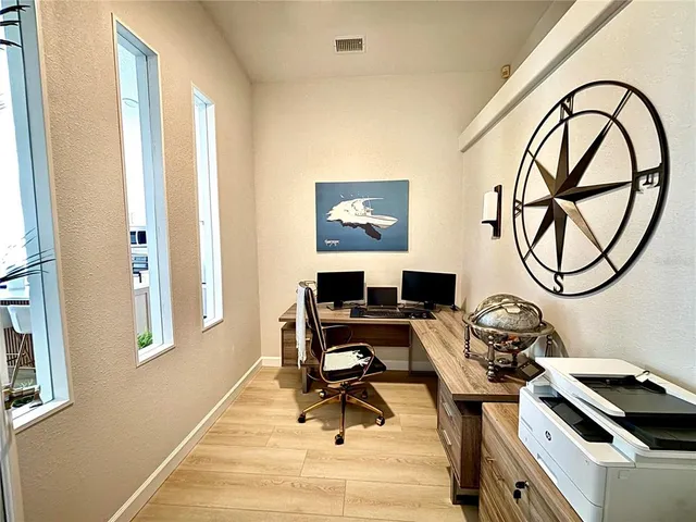 a view of a workspace with furniture and a window