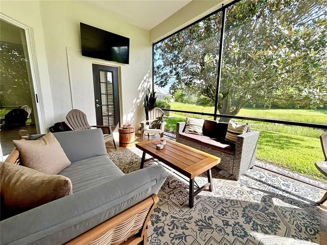 a outdoor living room with furniture and a flat screen tv
