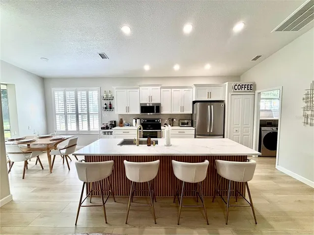 a large kitchen with a table and chairs