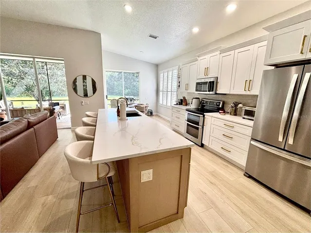 a large kitchen with a large window and stainless steel appliances