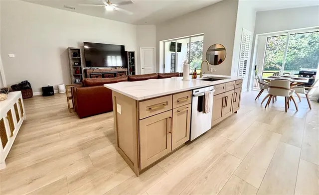 a kitchen with stainless steel appliances a stove top oven a sink a dining table and chairs