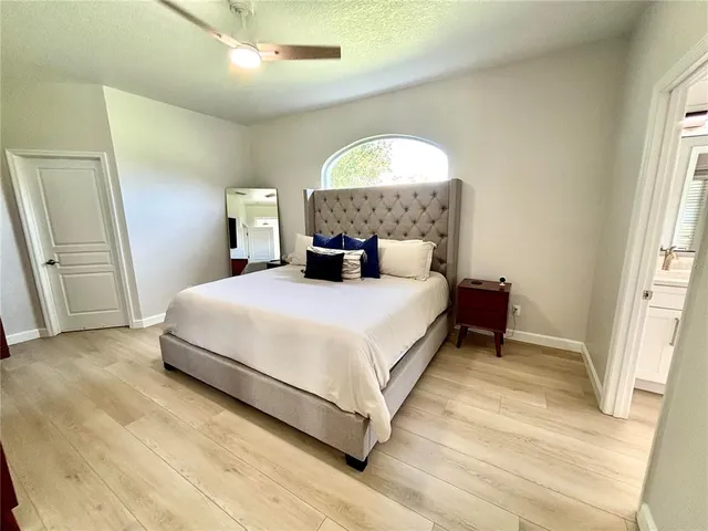 a bedroom with a bed lamp and a large window