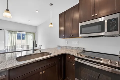 a kitchen with stainless steel appliances granite countertop a sink stove and microwave