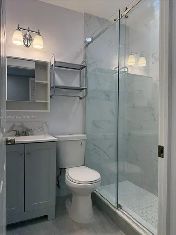 a bathroom with a shower a toilet and sink