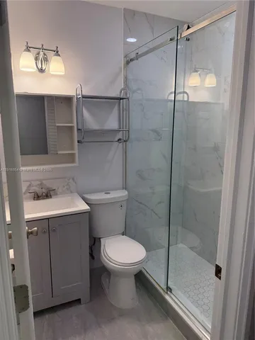 a bathroom with a shower a toilet and sink