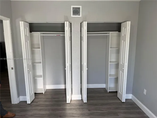 an empty room with wooden floor and closet