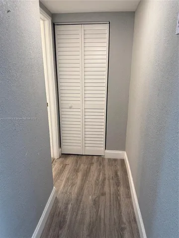 a view of a room with wooden floor and a window
