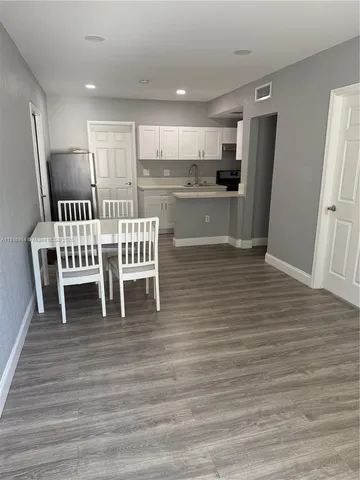 a view of kitchen with refrigerator stove and wooden floor