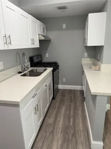 a kitchen with a sink a stove and cabinets