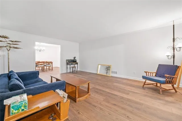 a living room with furniture a table and wooden floor