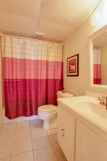 a bathroom with a sink a toilet and shower curtain
