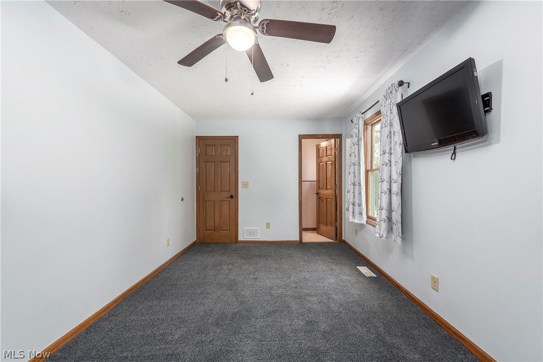 9990 Broadview Road Broadview Heights, OH 44147 - Photo 22 of 47 Unfurnished bedroom with carpet, a ceiling fan, a textured ceiling, and ensuite bath
