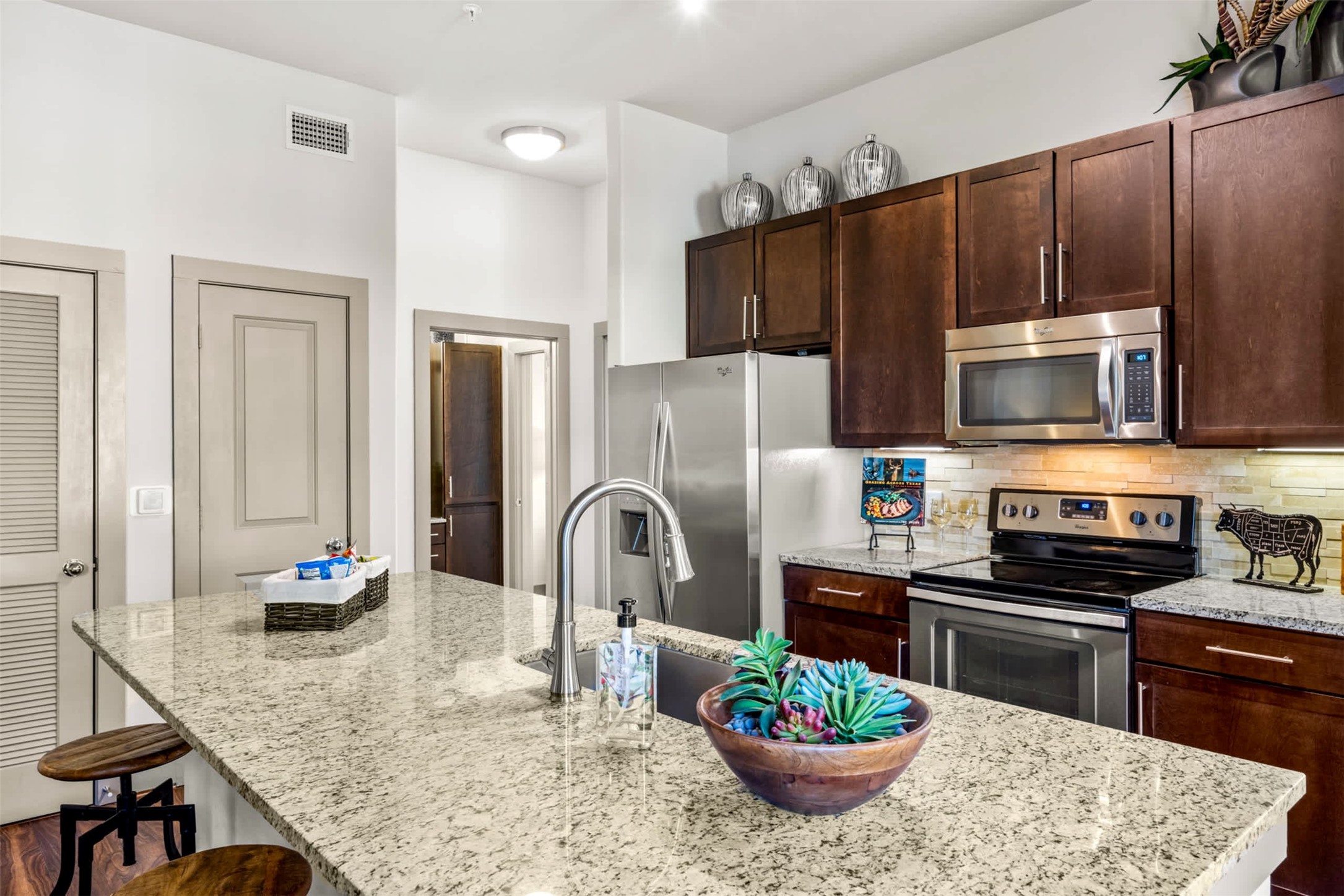 8100 Anderson Mill Road, Unit 2301 Austin, TX 78729 - Photo 5 of 19 a kitchen with stainless steel appliances kitchen island granite countertop a refrigerator stove and sink