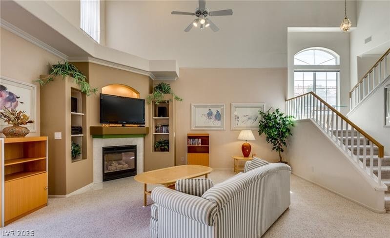 5272 Island Chain Road Las Vegas, NV 89118 - Photo 24 of 31 Sun-filled living area featuring a cozy fireplace and convenient staircase access to the upper level.