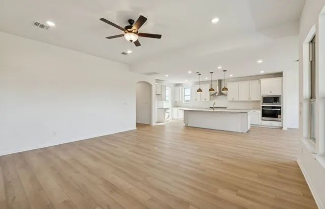an empty room with wooden floor and fireplace