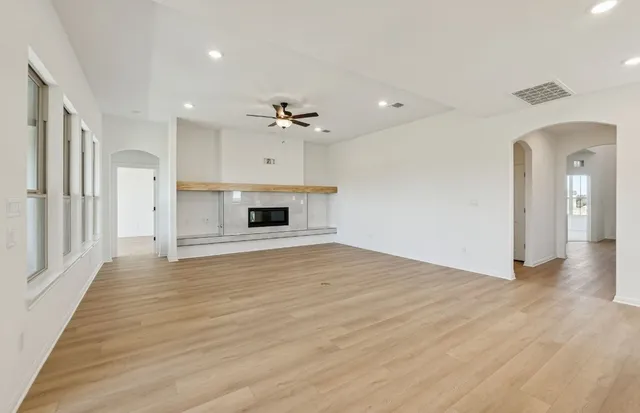 a view of empty room with wooden floor and window