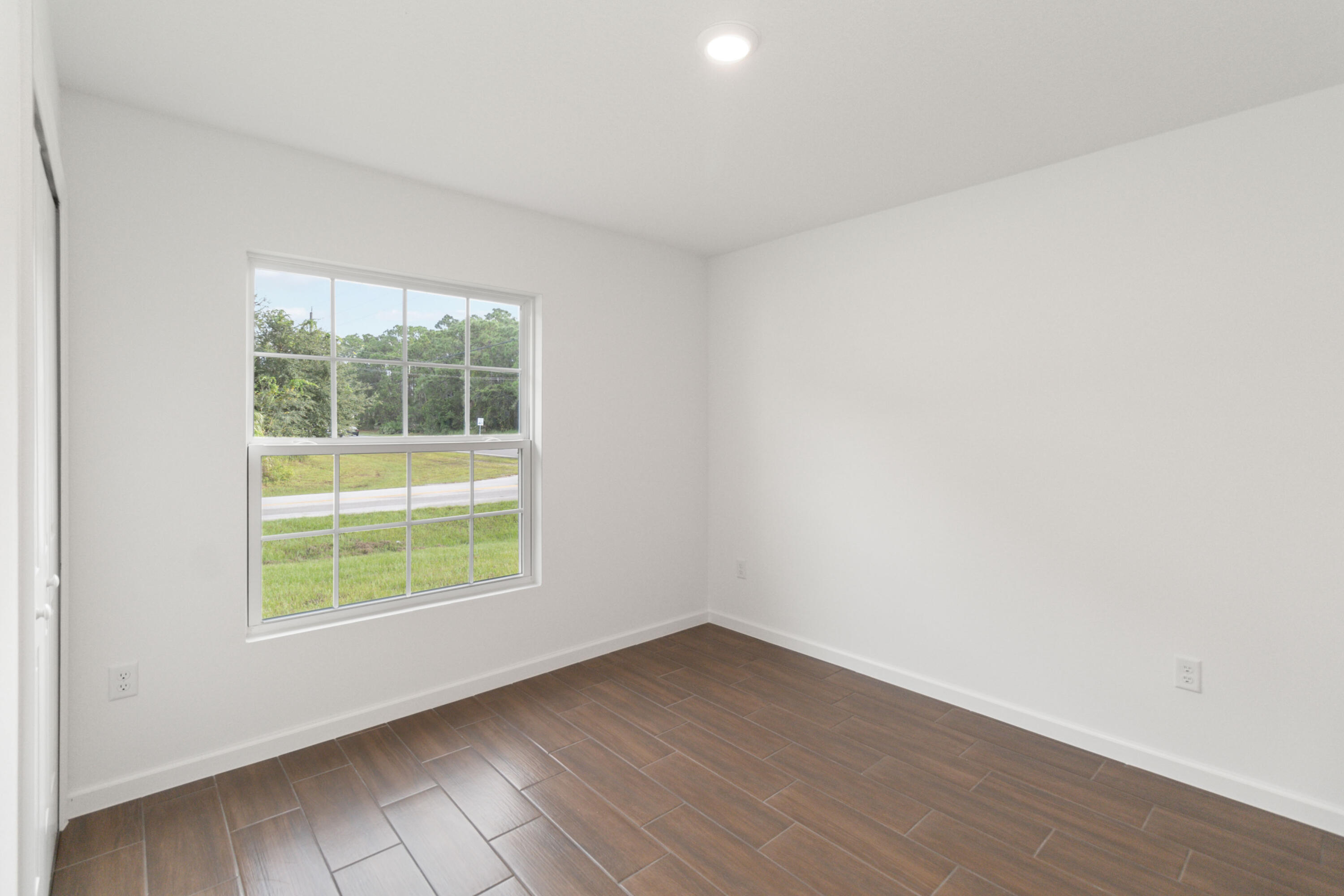 336 Rheine Road Northwest Palm Bay, FL 32907 - Photo 26 of 30 an empty room with wooden floor and windows