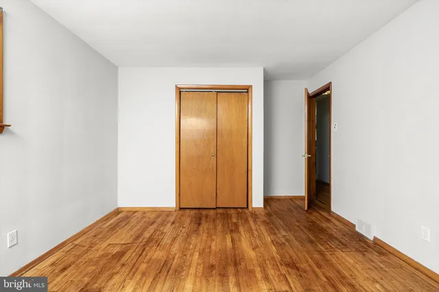 an empty room with wooden floor and closet