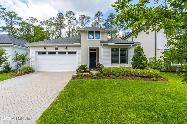 a front view of a house with a yard and trees