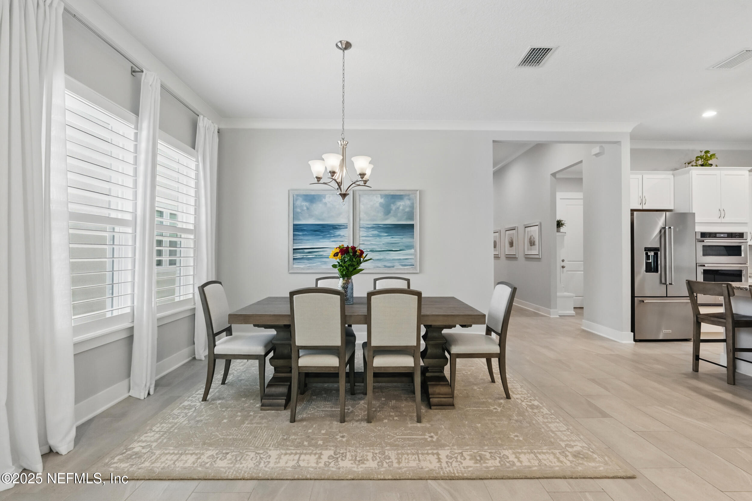 9918 Filament Boulevard Jacksonville, FL 32256 - Photo 21 of 106 a dining room with furniture a chandelier and wooden floor