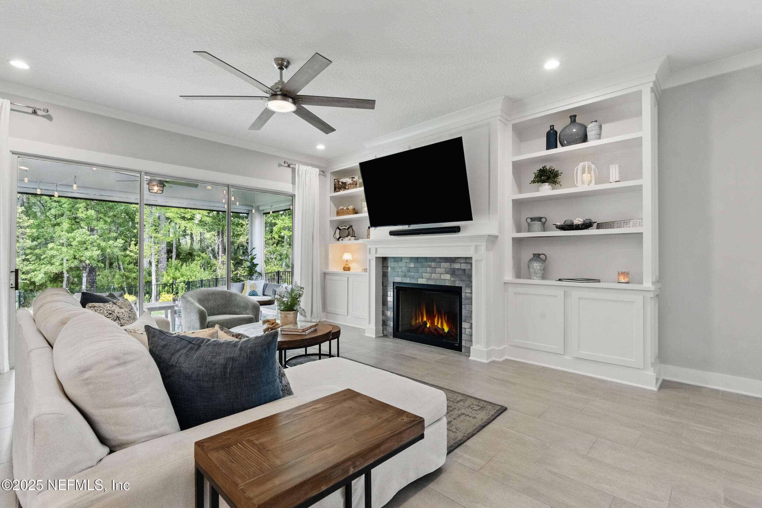 9918 Filament Boulevard Jacksonville, FL 32256 - Photo 23 of 106 a living room with furniture a fireplace and a flat screen tv