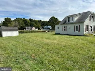 a front view of a house with a garden and trees