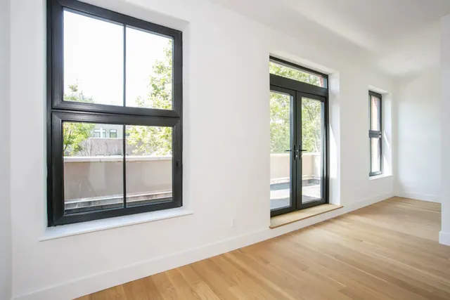 a bedroom with a bed and a large window