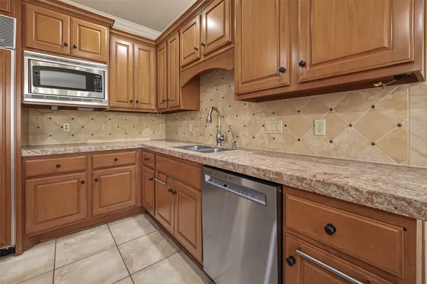 a kitchen with granite countertop a stove top oven microwave and cabinets