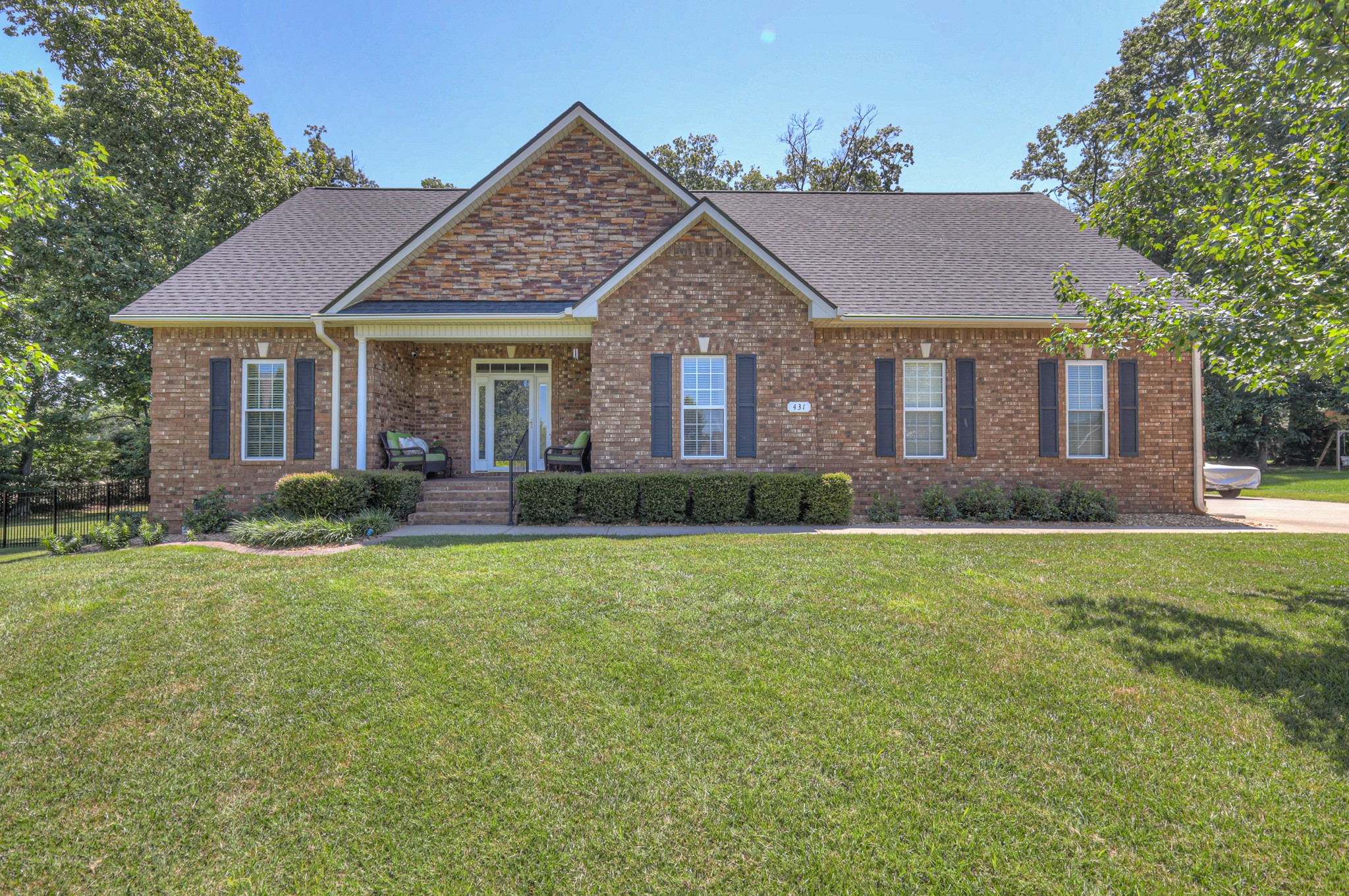 a view of a house next to a yard with plants and trees