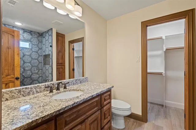 a bathroom with a granite countertop sink toilet and shower