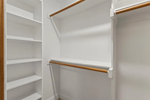 a view of walk in closet with empty racks