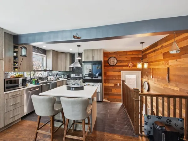 a kitchen with stainless steel appliances wooden floor dining table and chairs