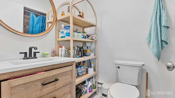 a bathroom with a toilet a sink and a mirror