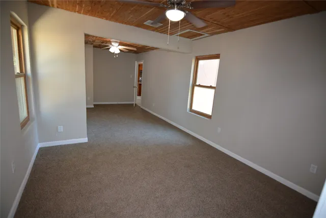 an empty room with windows and closet
