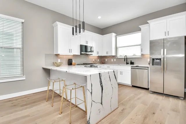 a kitchen with stainless steel appliances granite countertop a stove sink and cabinets