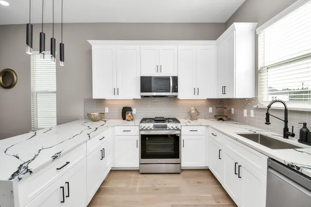 a kitchen with a sink a refrigerator and cabinets