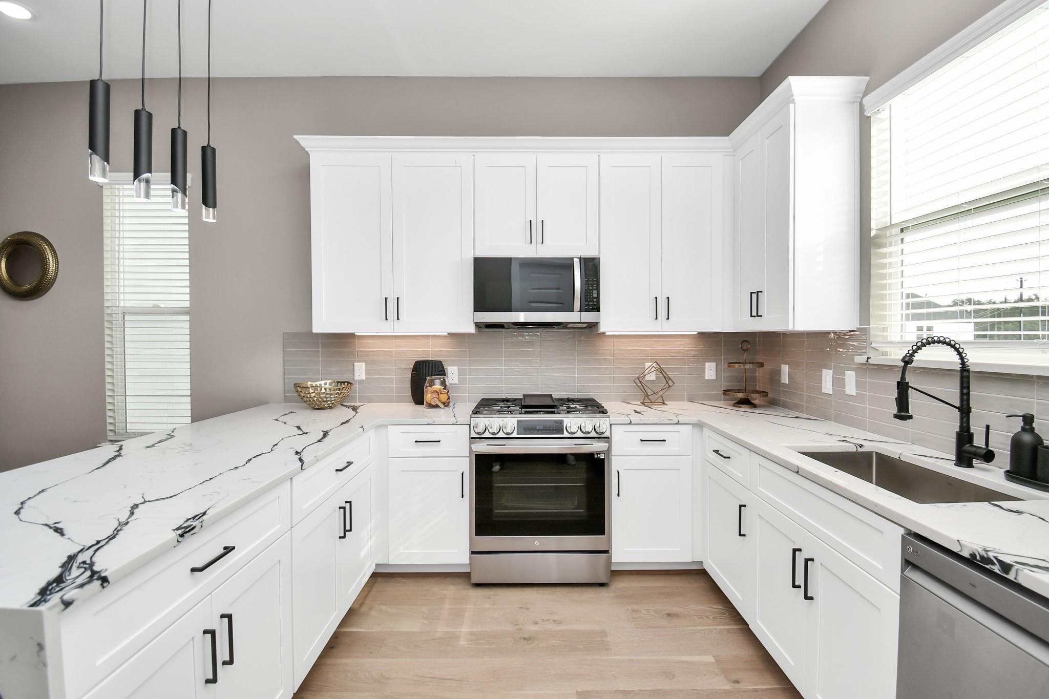 316 Thornton Road, Unit E Houston, TX 77018 - Photo 13 of 27 a kitchen with stainless steel appliances granite countertop a stove sink and cabinets