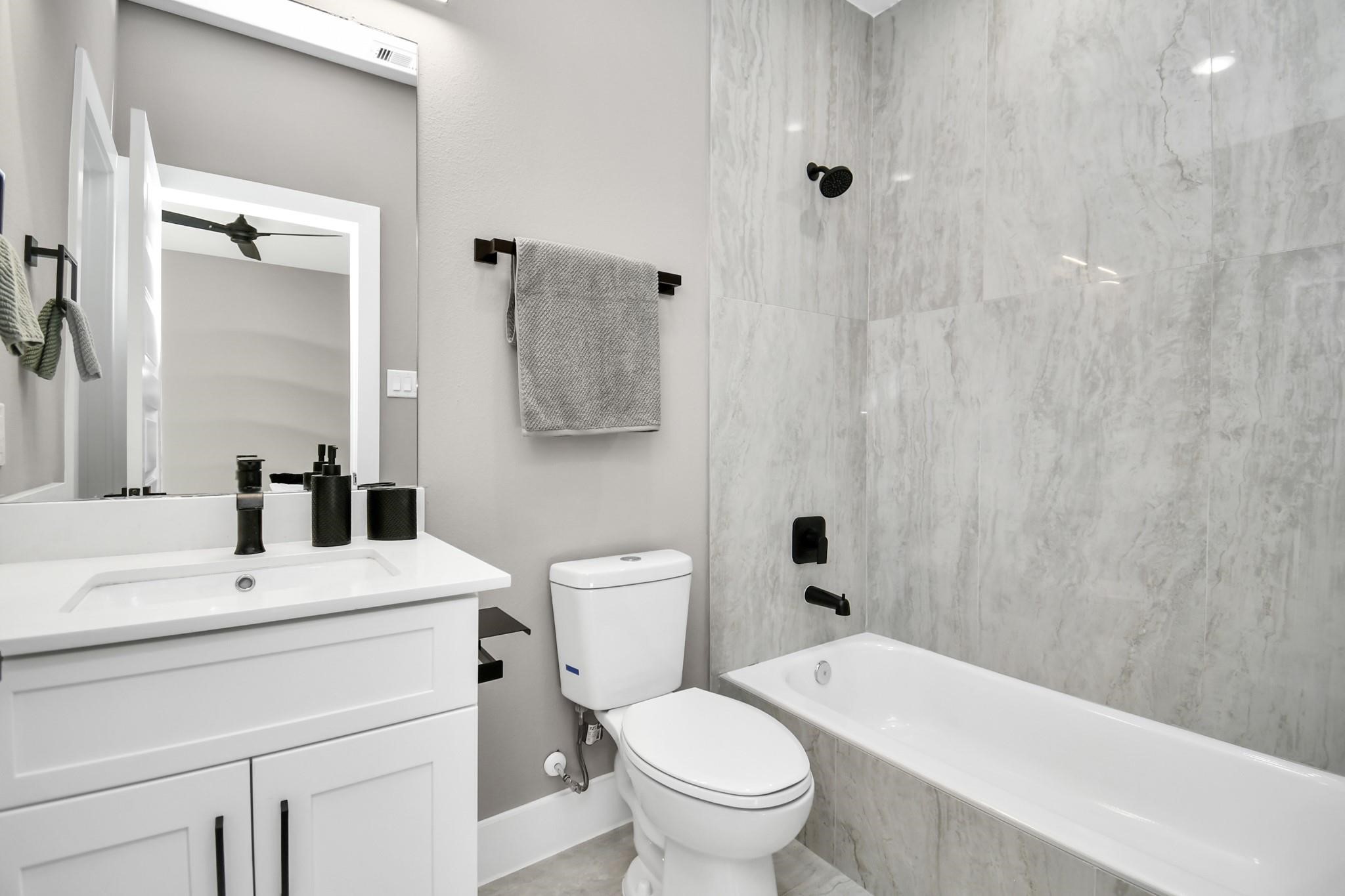 316 Thornton Road, Unit E Houston, TX 77018 - Photo 4 of 27 a bathroom with a sink a toilet and shower curtain