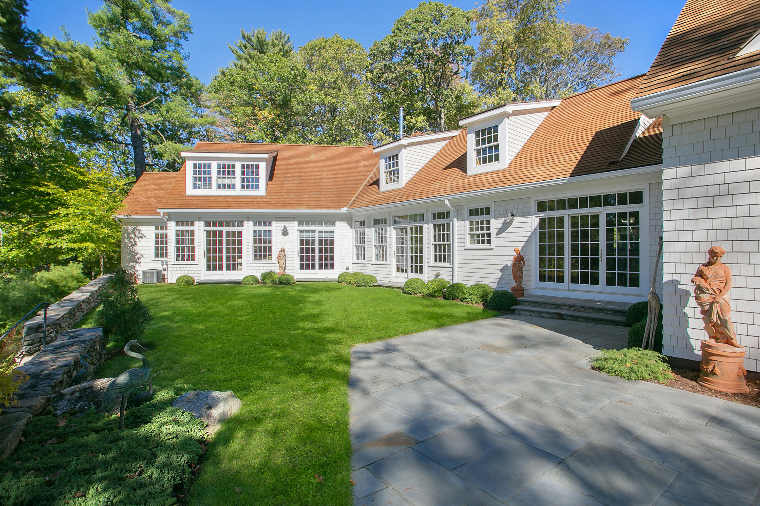 65 Goodwives River Road Darien, CT 06820 - Photo 26 of 36 a front view of a house with a yard and garage