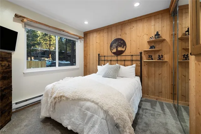 a bedroom with a bed and a large window