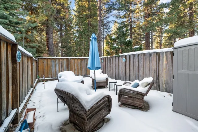 a view of backyard with outdoor seating and wooden fence