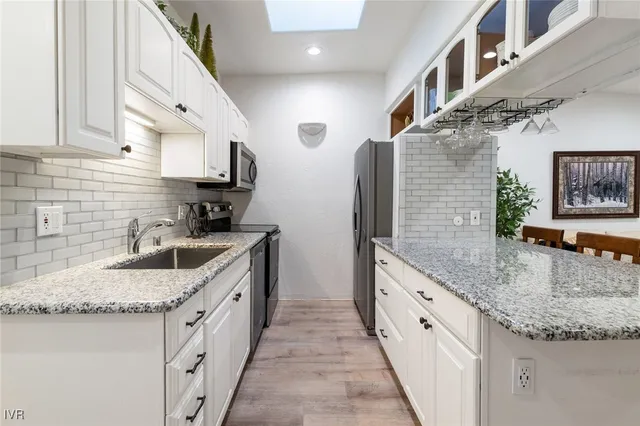 a kitchen with stainless steel appliances granite countertop a sink stove and cabinets