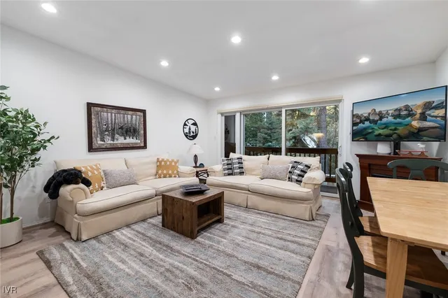 a living room with furniture potted plant and a large window