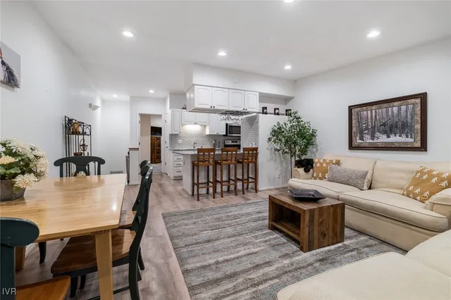 a living room with furniture kitchen view and a potted plant